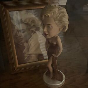 Elegant Blonde Figurine with Framed Art